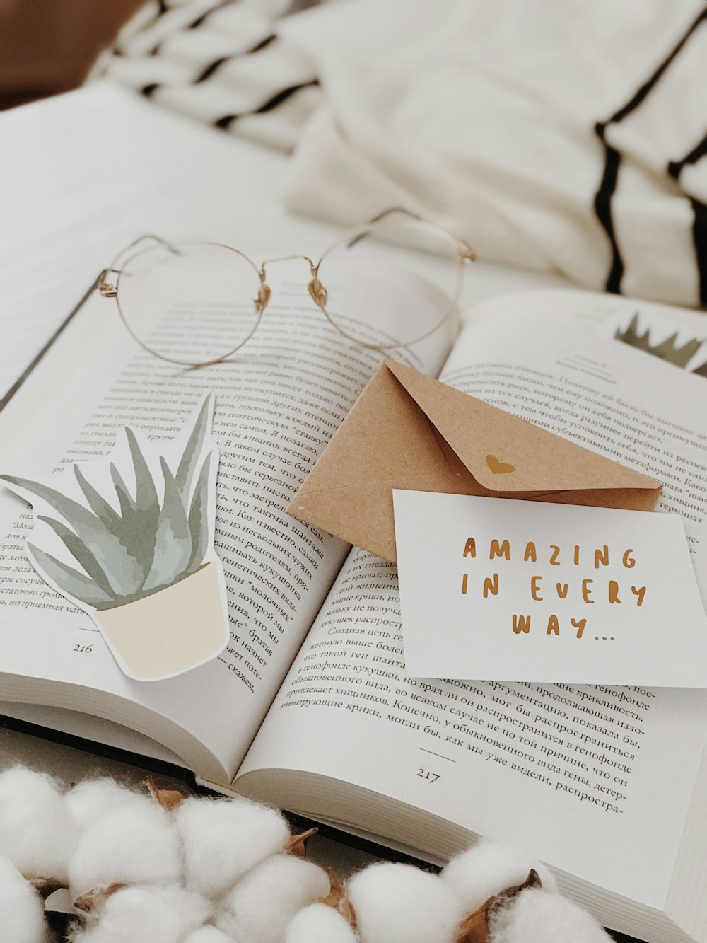 eyeglasses on book near envelope