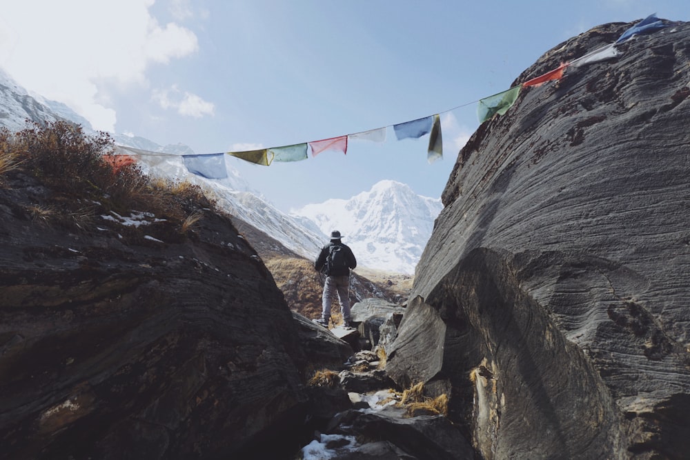 Hombre de pie en la roca frente a las montañas glaciares en la distancia