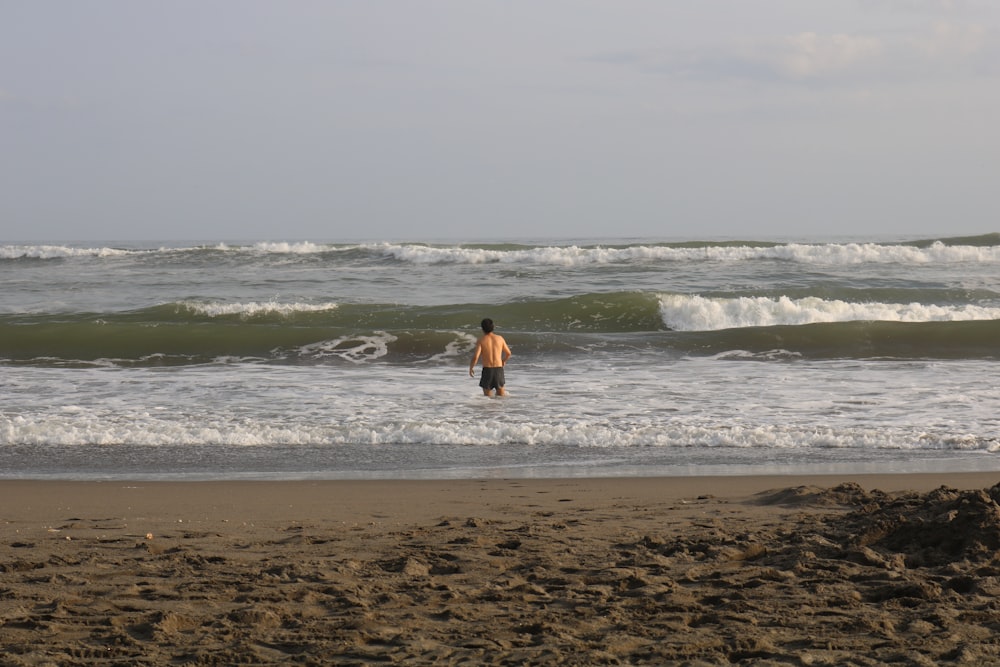 man in black shorts in ocean