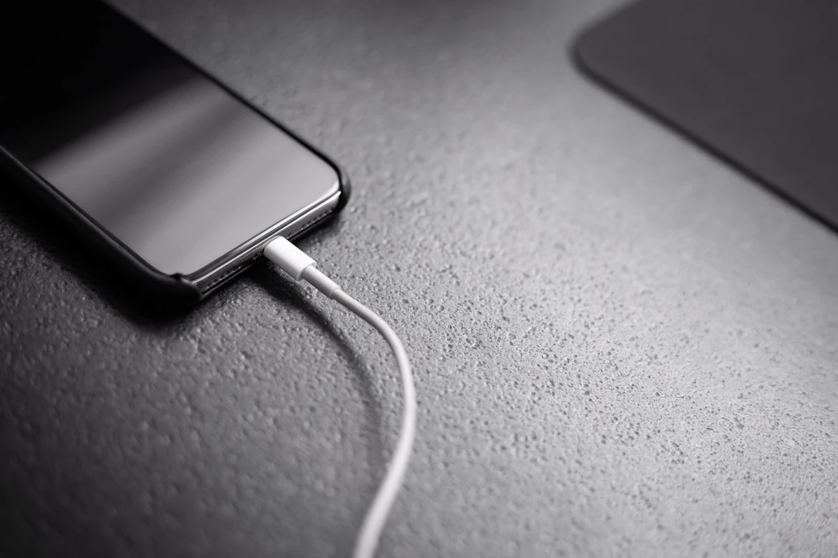 iPhone 14 Plus with its Face ID notch design plugged in to charge during real-world battery testing on iOS 27 Developer Beta