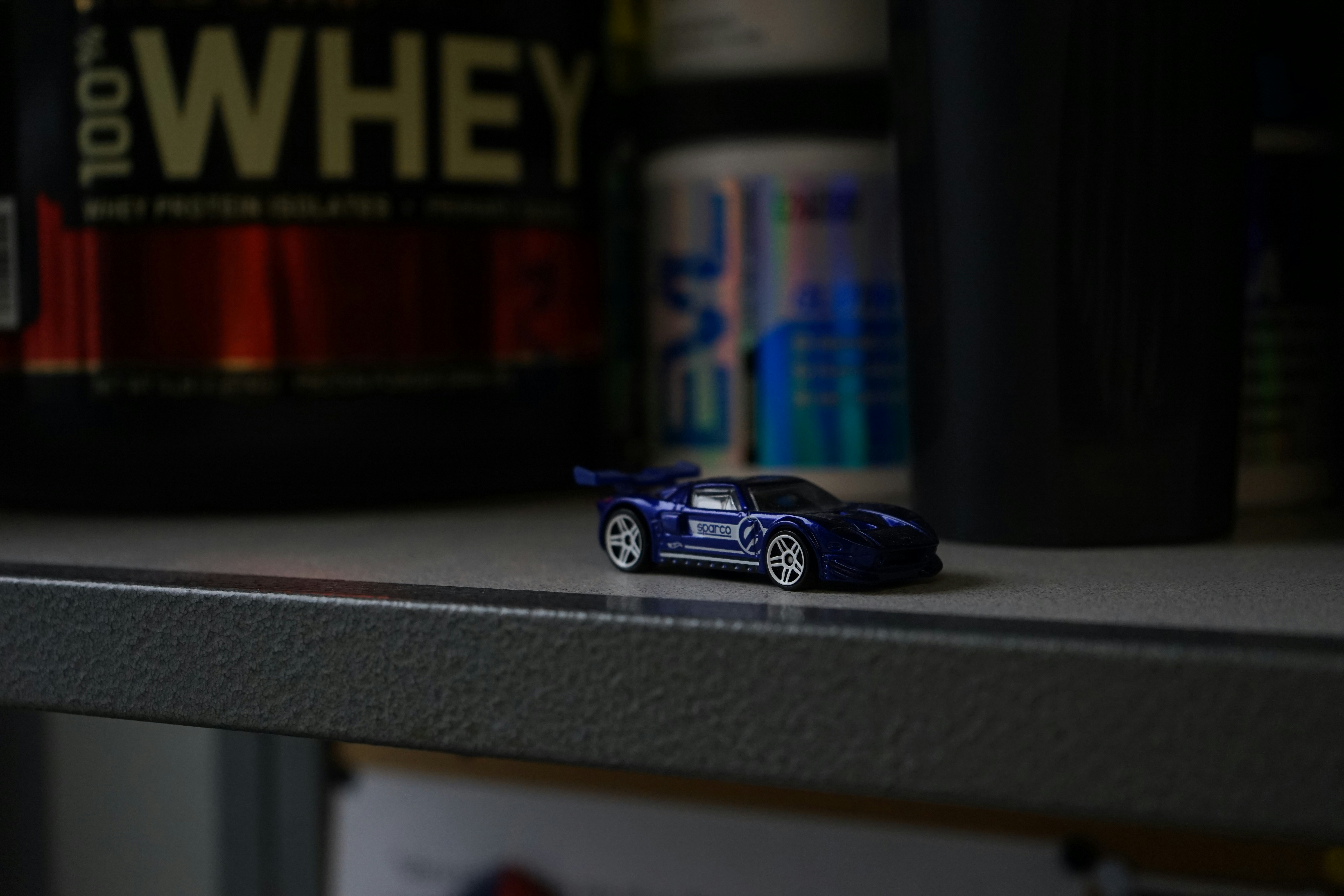 blue sports car die-cast miniature on shelf