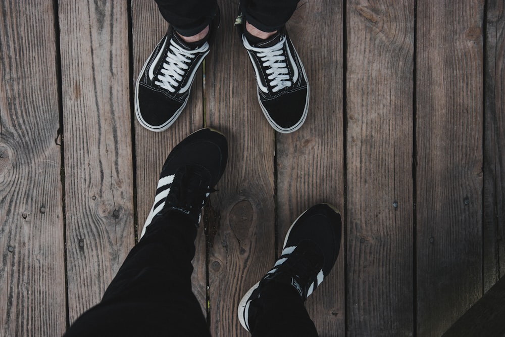 personne portant des chaussures Vans Old Skool noires et blanches