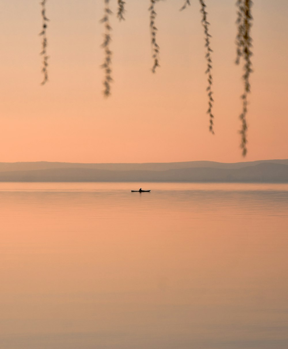 boat on calm body of water during golden hour