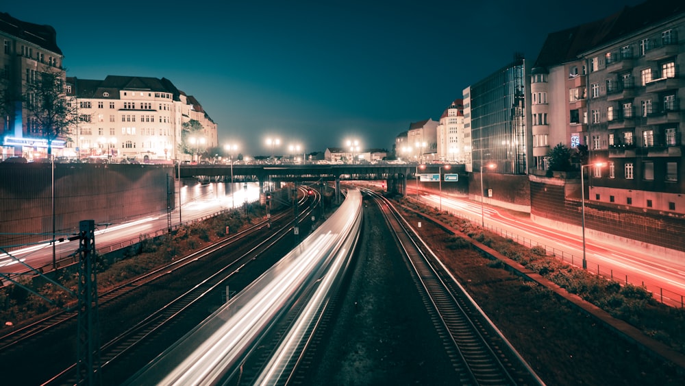 concrete road between building in timelapse photo at nighttime