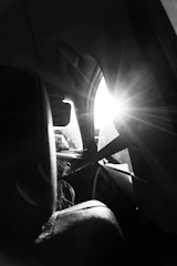 Artistic shot of sunlight filtering through tinted glass on a vehicle.