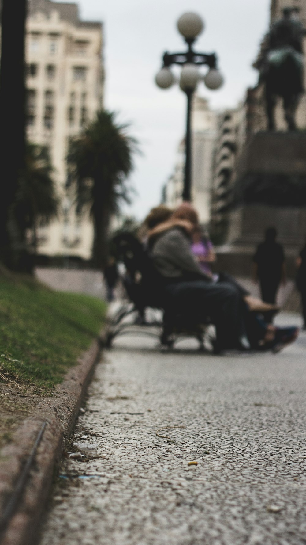 people sitting on benches near lamppost