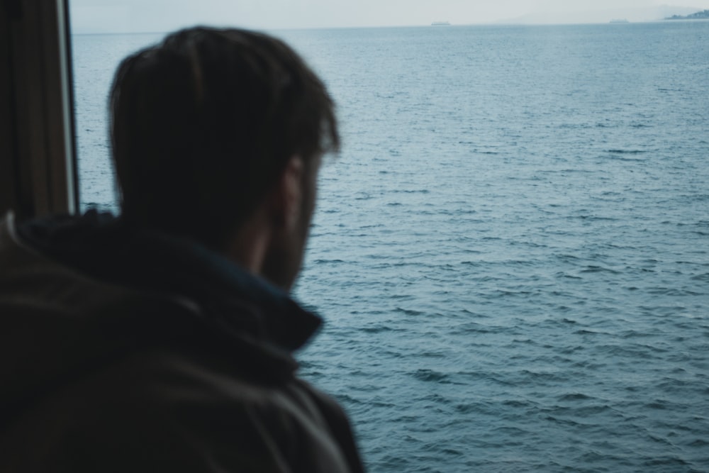man standing near calm ocean