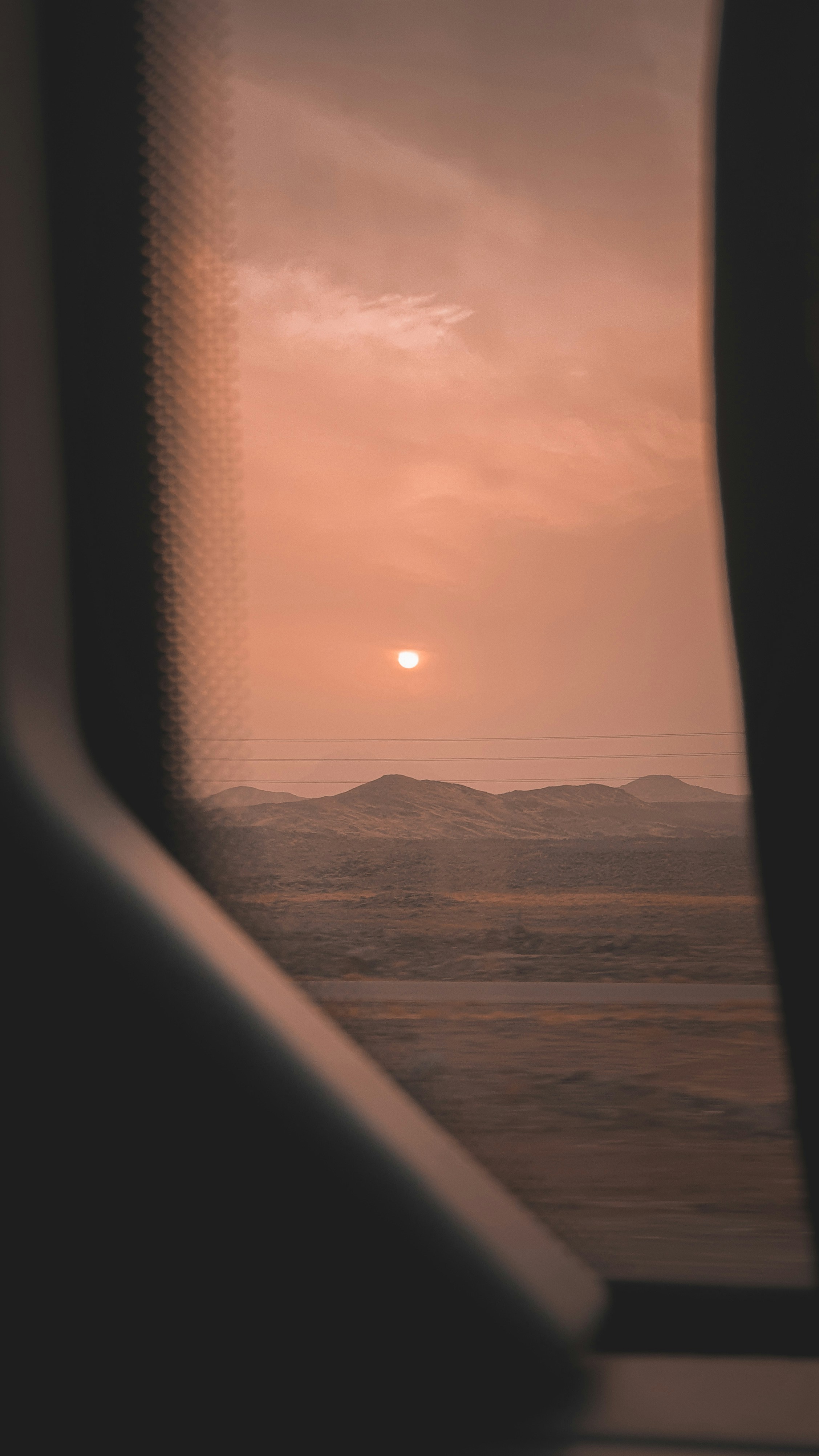 the sun is setting over the mountains in the distance