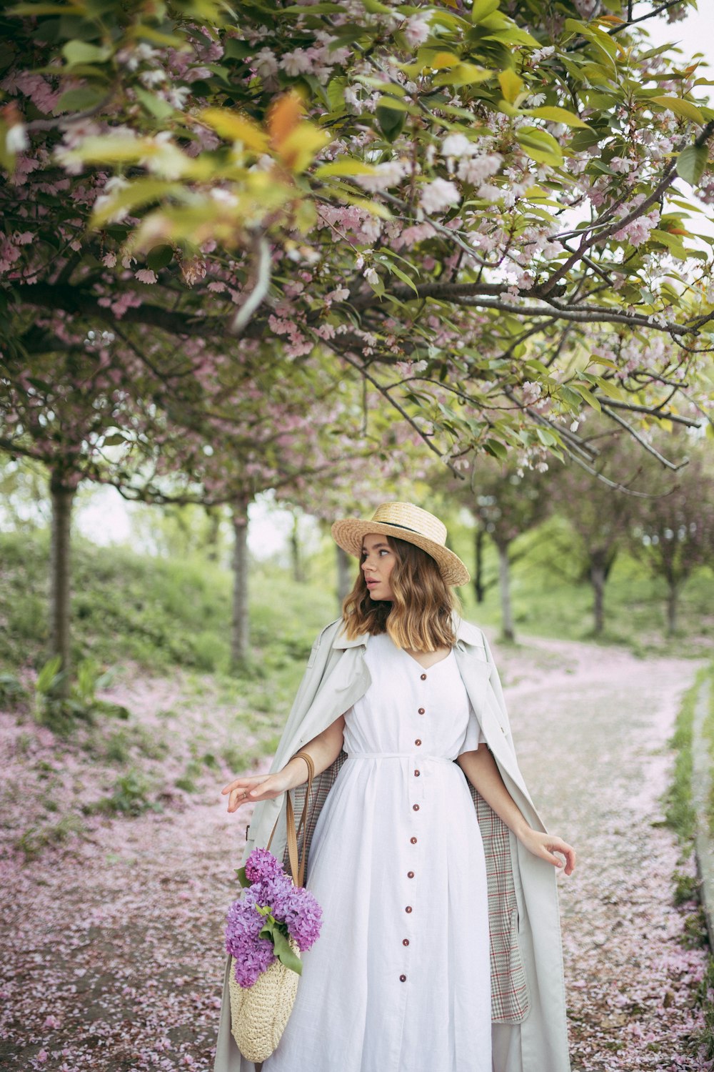 woman looking to her left carrying bag with flower at daytime