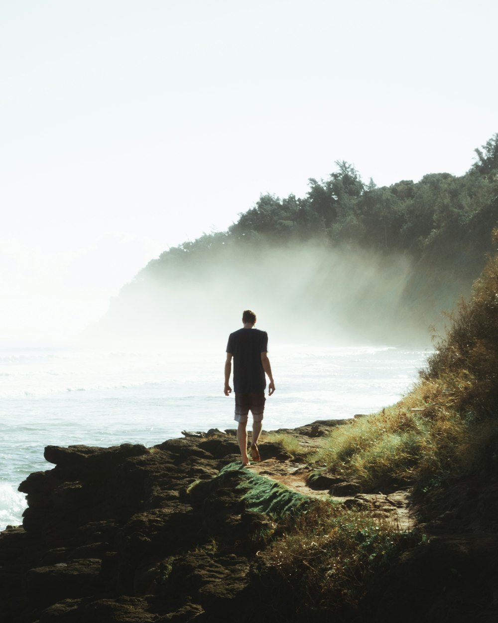 man in black walking on a seaside cliff