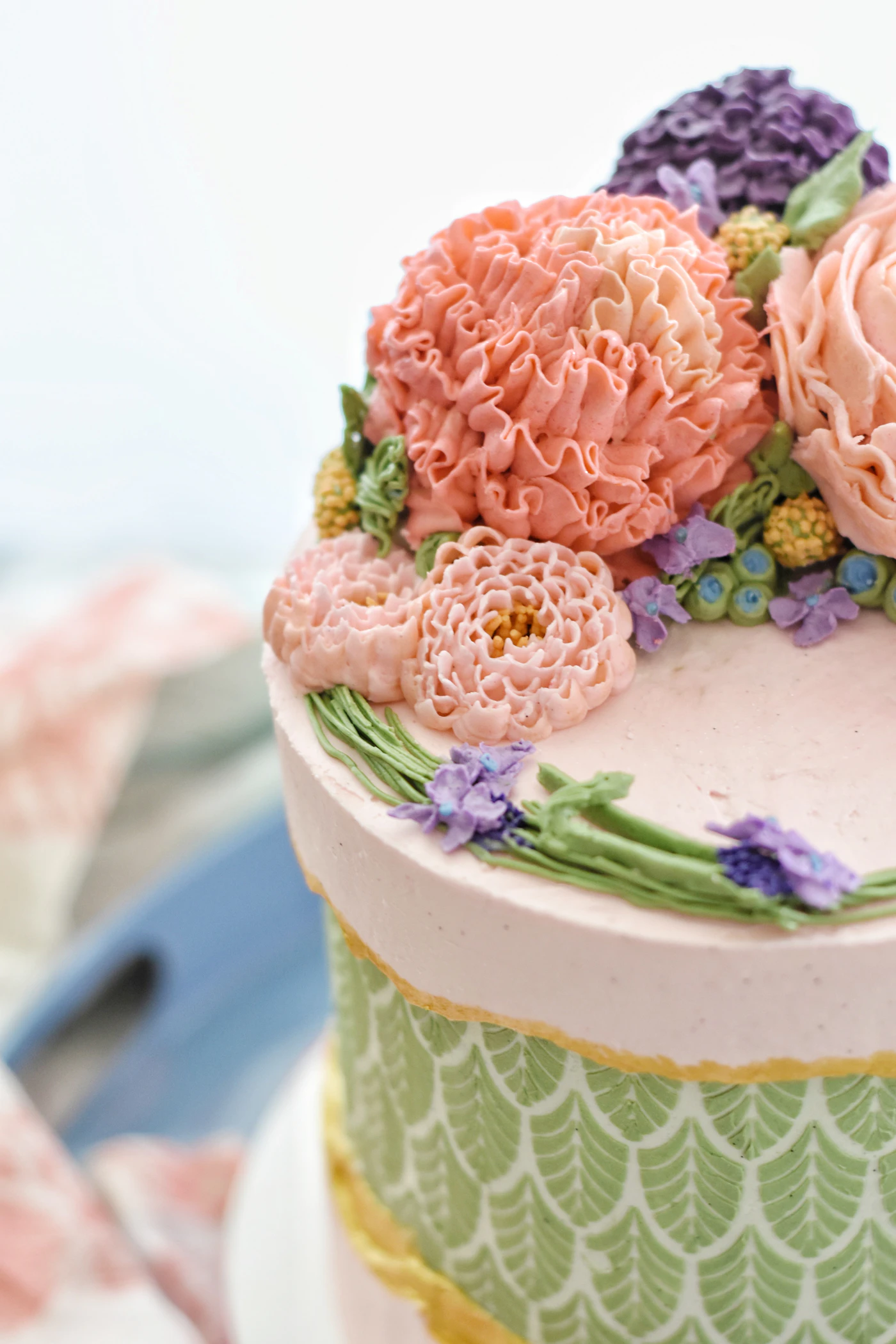 DIY wedding cake decorating tips — Professional decorating tools including a turntable and bench scraper beside a cake