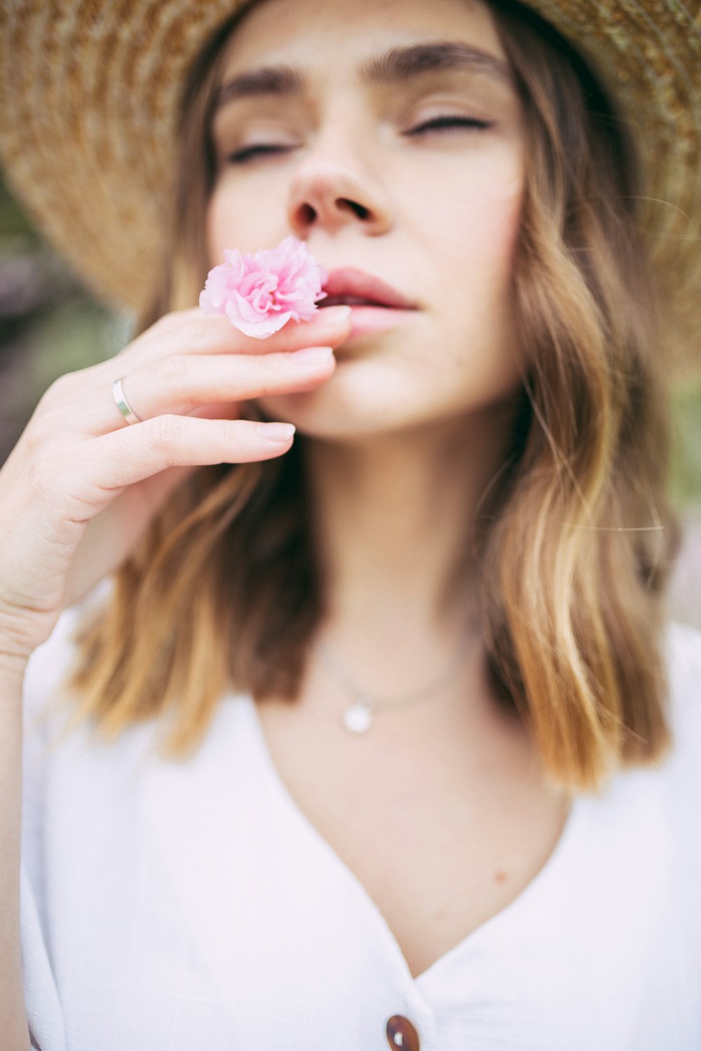 ピンクの花の匂いを嗅ぐ女性