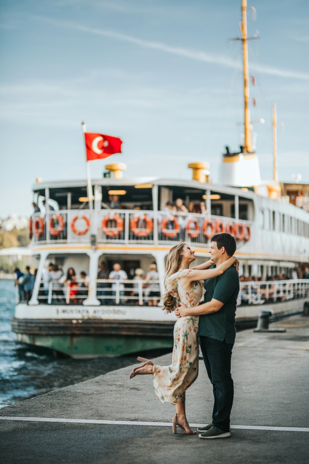 uomo e donna in piedi e abbracciati mentre si trovano l'uno di fronte all'altro vicino alla nave da crociera