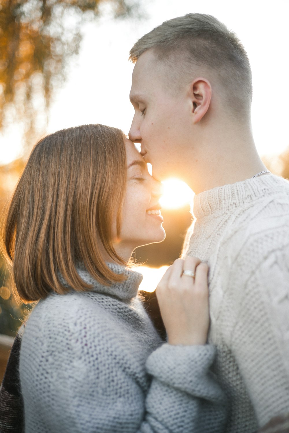 man kissing woman's forehead