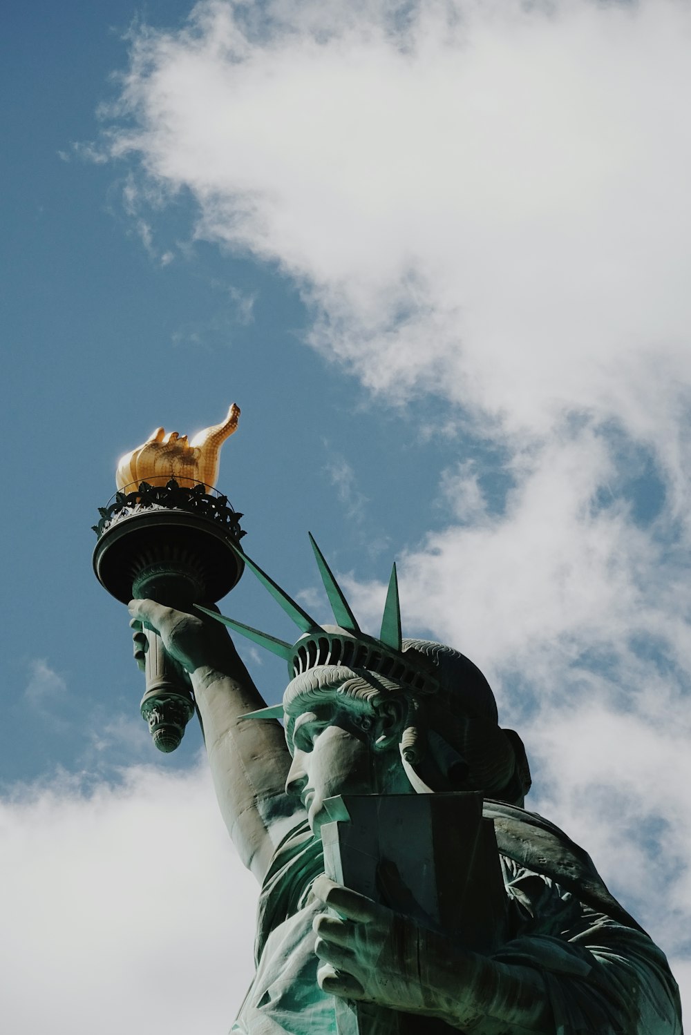 Statue of Liberty in New York City under blue and white skies