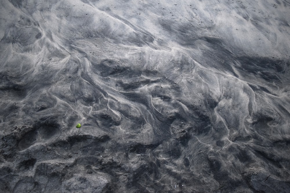 a green tennis ball is in the sand