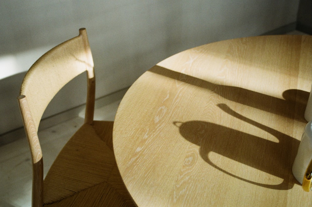 Mesa redonda de madera marrón y silla sin brazos de madera marrón
