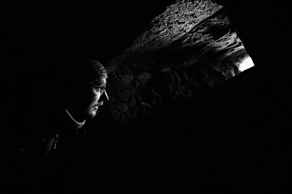 a black and white photo of a man in the dark