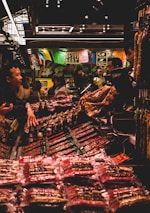A bustling Asian market scene showing customers engaging with imported food products.