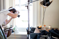 Behind-the-scenes shot of a photo session capturing artisanal dishes with soft natural light.