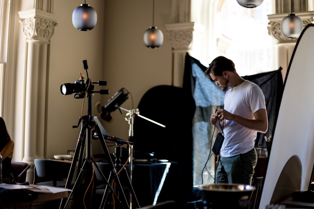 man standing near cameras on tripods