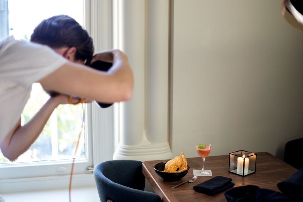 man stooping in front of dining table