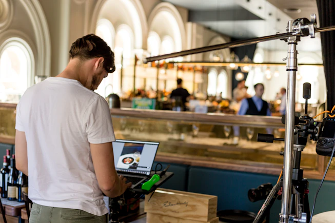 A friendly restaurant owner smiling while using a laptop to manage reservations
