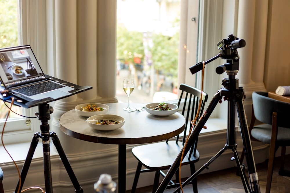 laptop computer near camera and table with food