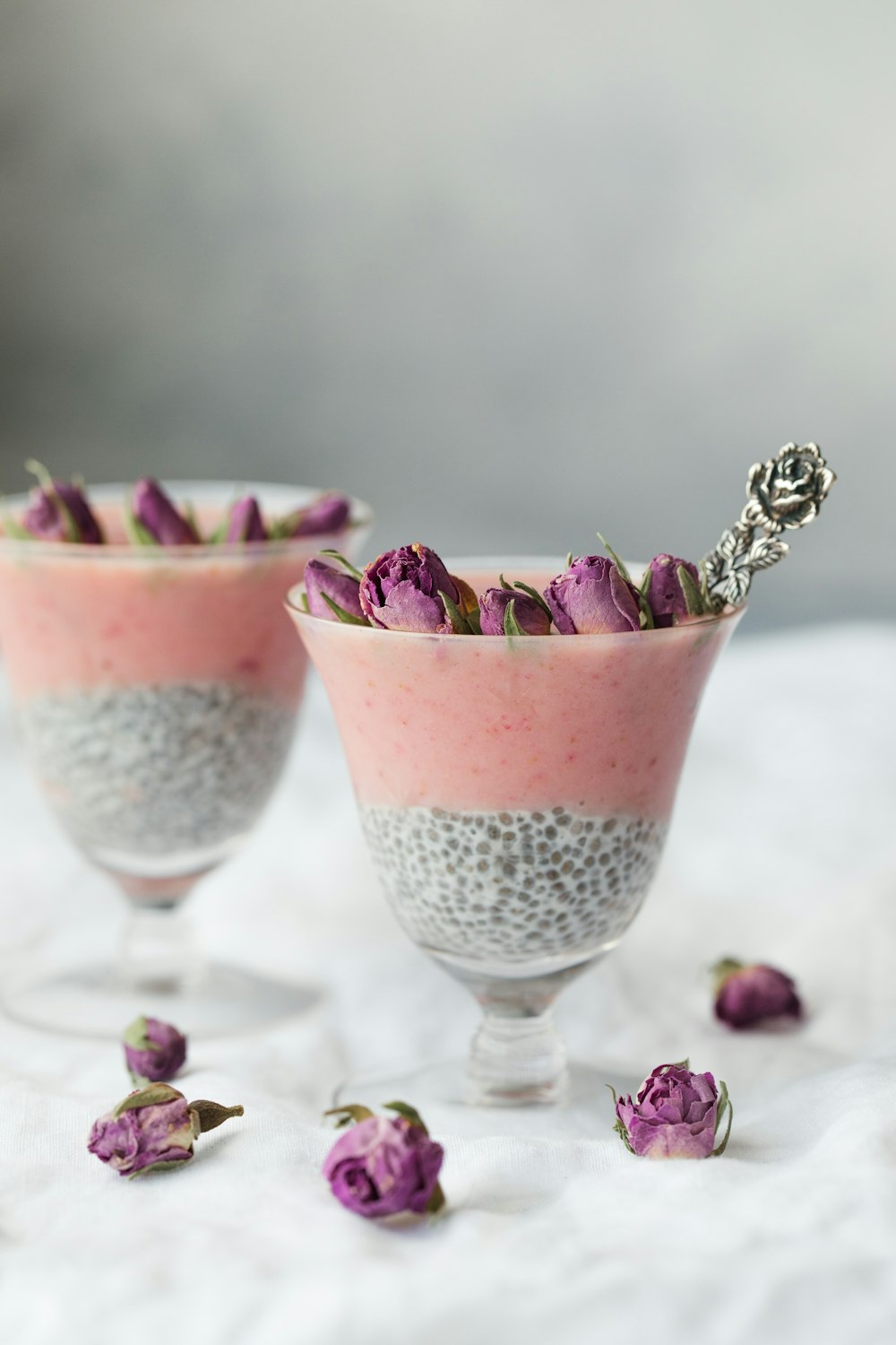 two pink tapioca dessert topped with pink rose buds
