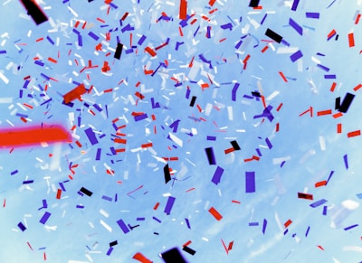 A festive banner with colorful balloons and confetti.