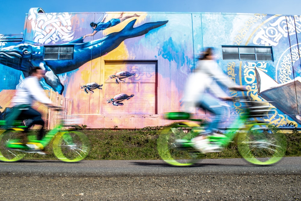 duas pessoas andando de bicicleta verde