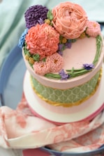 A beautifully decorated multi-tiered cake showcasing intricate custom artwork in soft pastel colors.