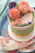 Close-up of a beautifully decorated blush pink and cream cake with delicate floral accents.