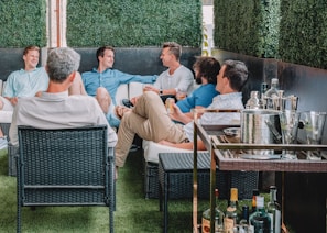 Men enjoying refreshments and laughter at the clubhouse patio after a tournament