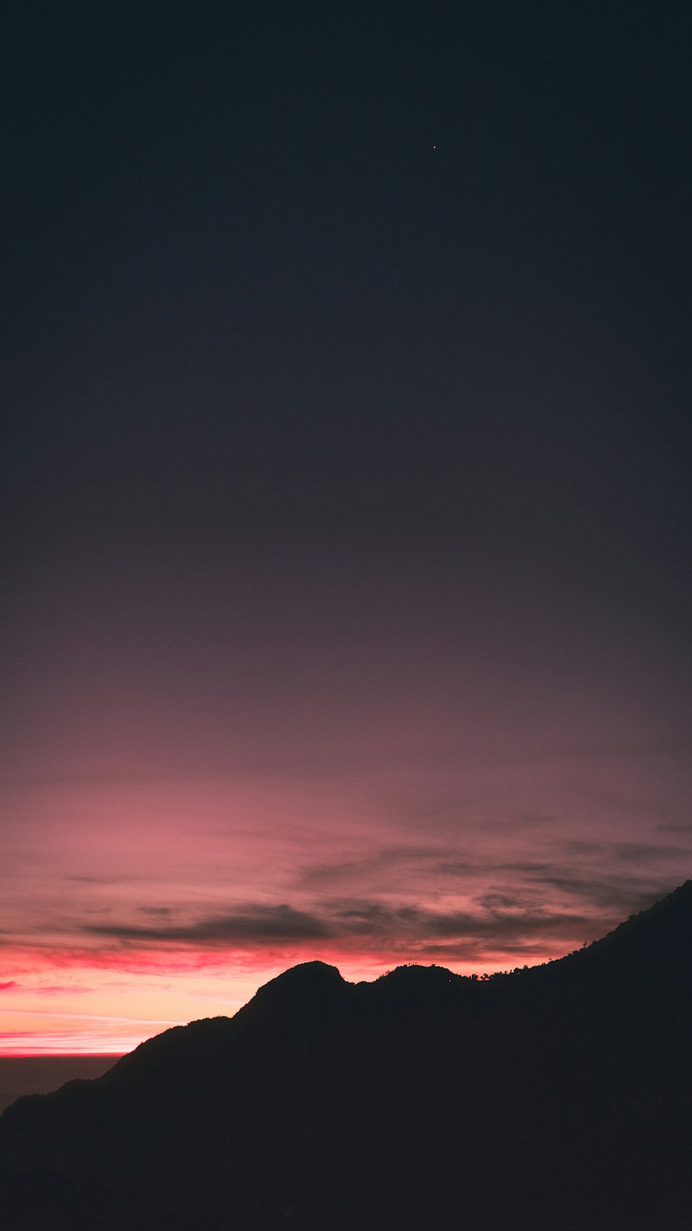 pink and grey sky over mountain during sunset
