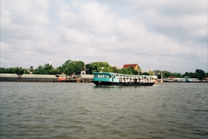 A sleek boat cruising on calm turquoise river waters