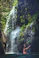 women under a waterfalls during daytime