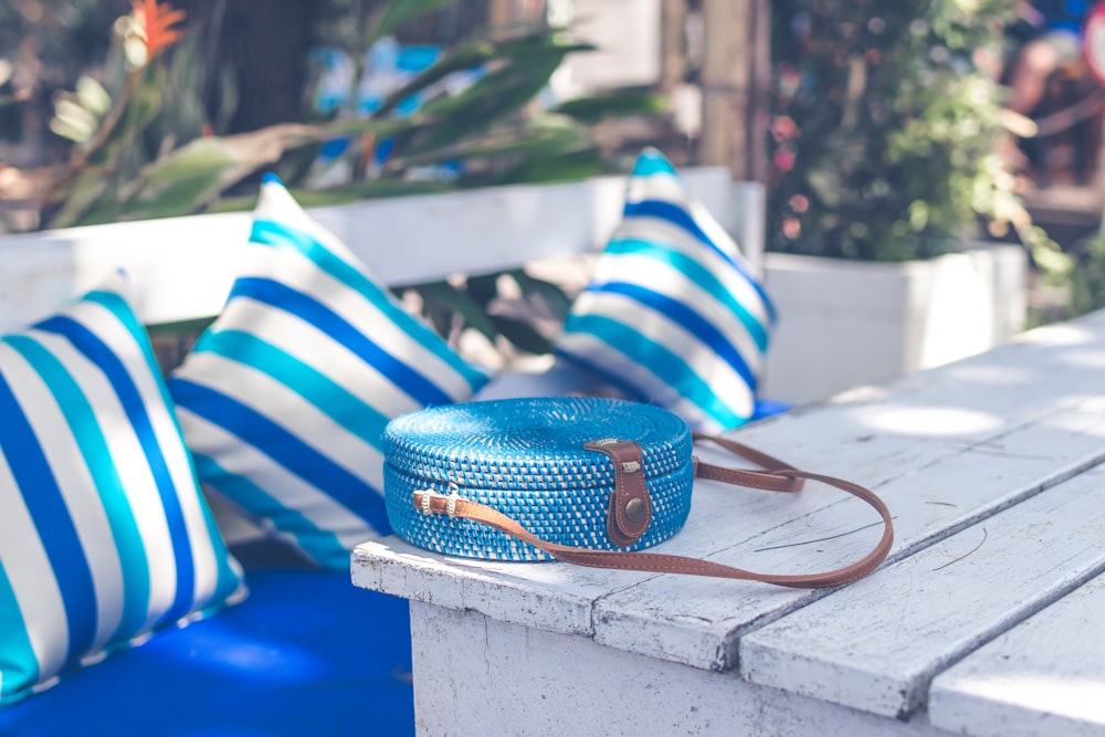 round blue crossbody bag on white table