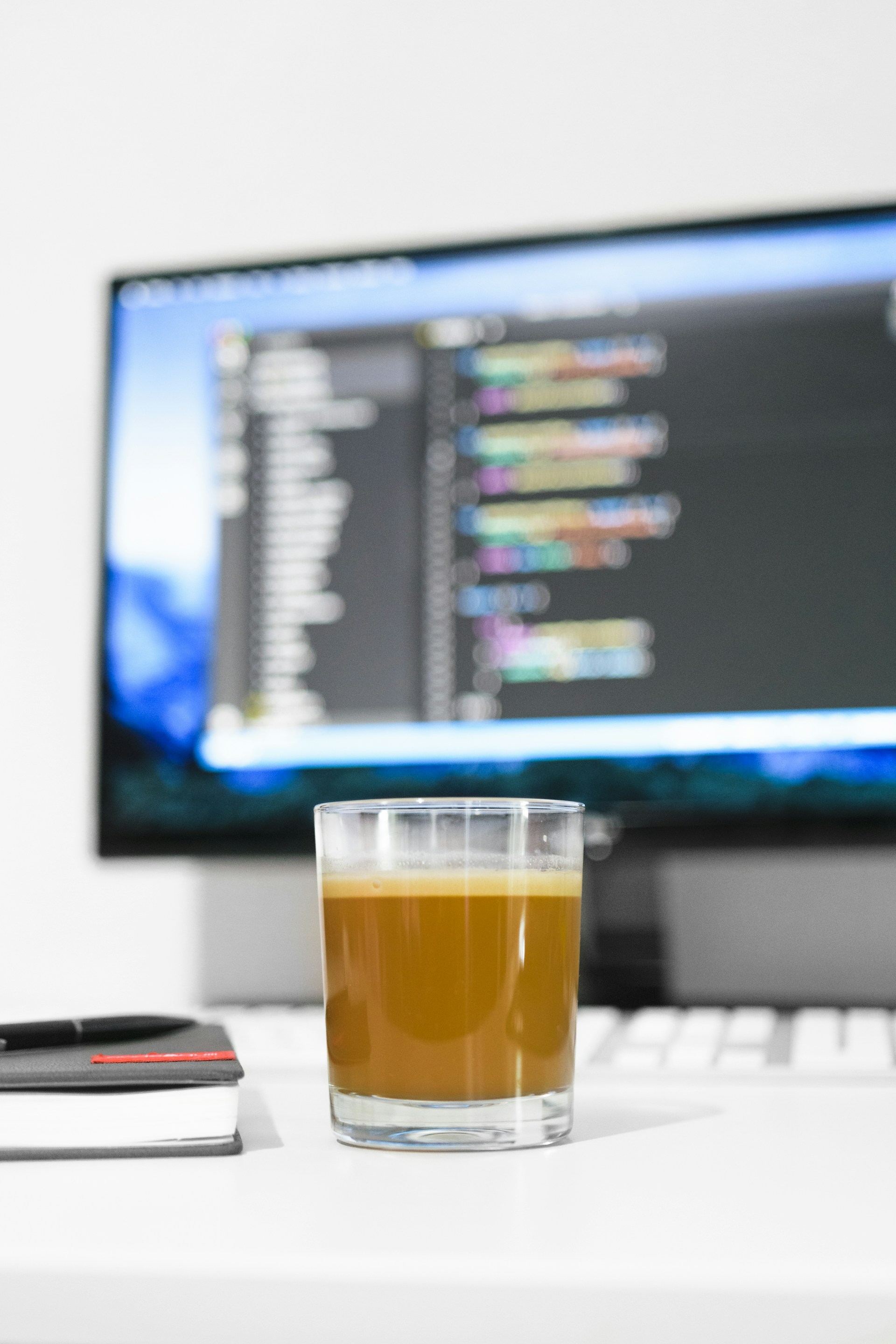 filled glass near monitor