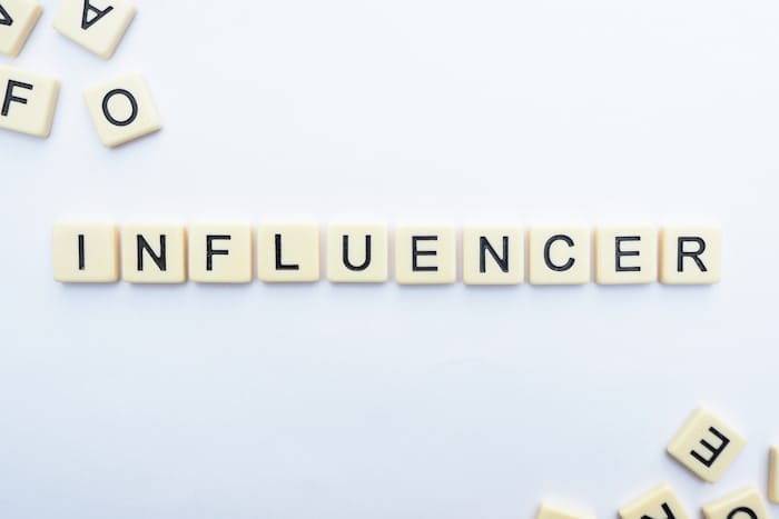 influencer, the word influencer spelled out using scrabble pieces