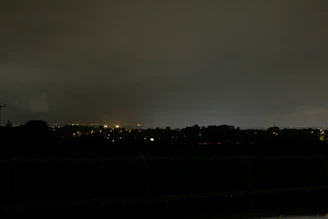 A peaceful nighttime cityscape with distant lights softened by a quiet, atmospheric haze.