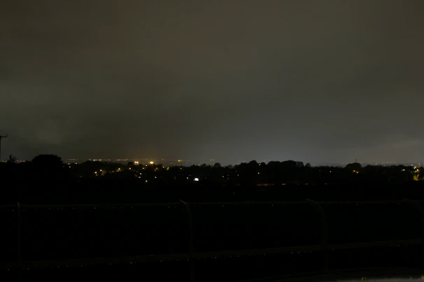 A peaceful nighttime cityscape with distant lights softened by a quiet, atmospheric haze.