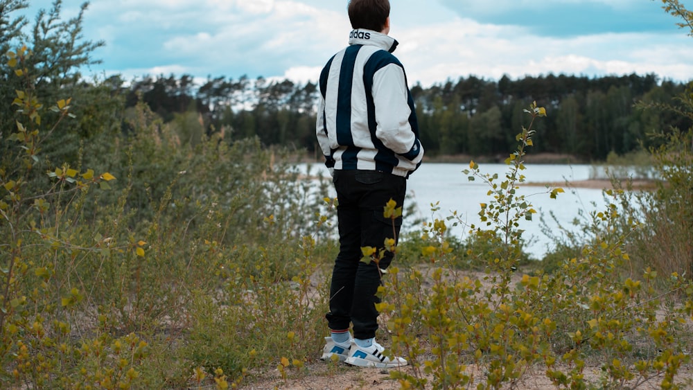 person wearing jacket facing body of water