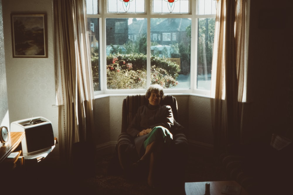 woman sitting on front of window