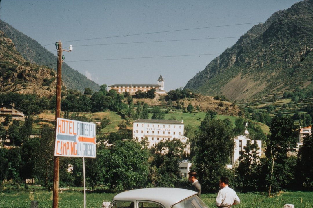 car parked beside people near sign and buildings at the distance