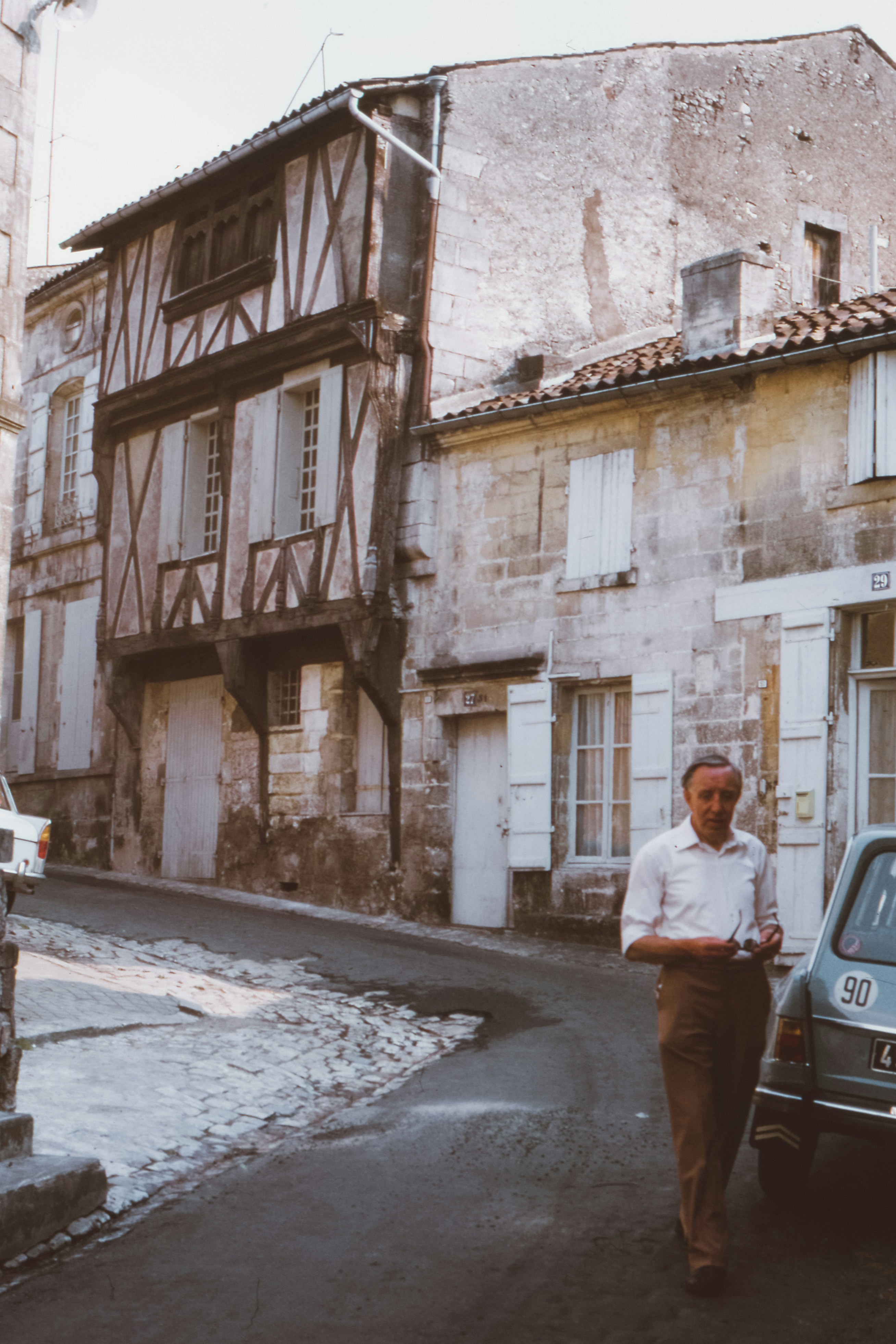 man standing beside gray car