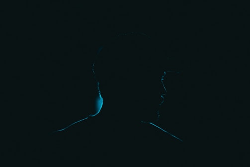 Close-up of a woman’s silhouette against a dark backdrop, highlighting curves.