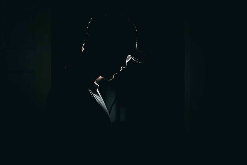 Una silhouette di una persona in una stanza buia
