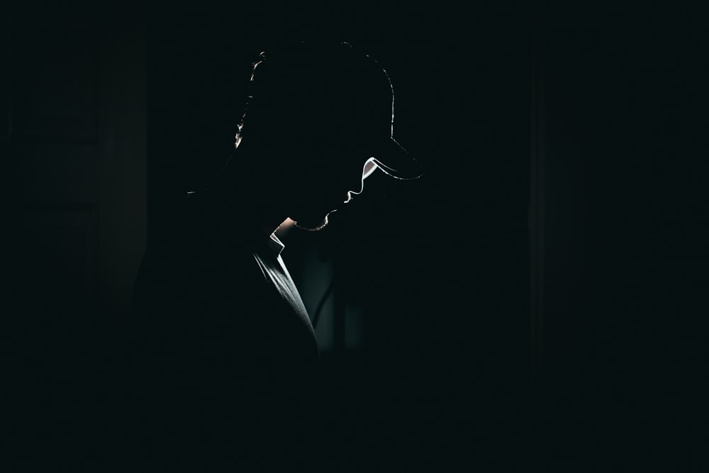 a silhouette of a person in a dark room