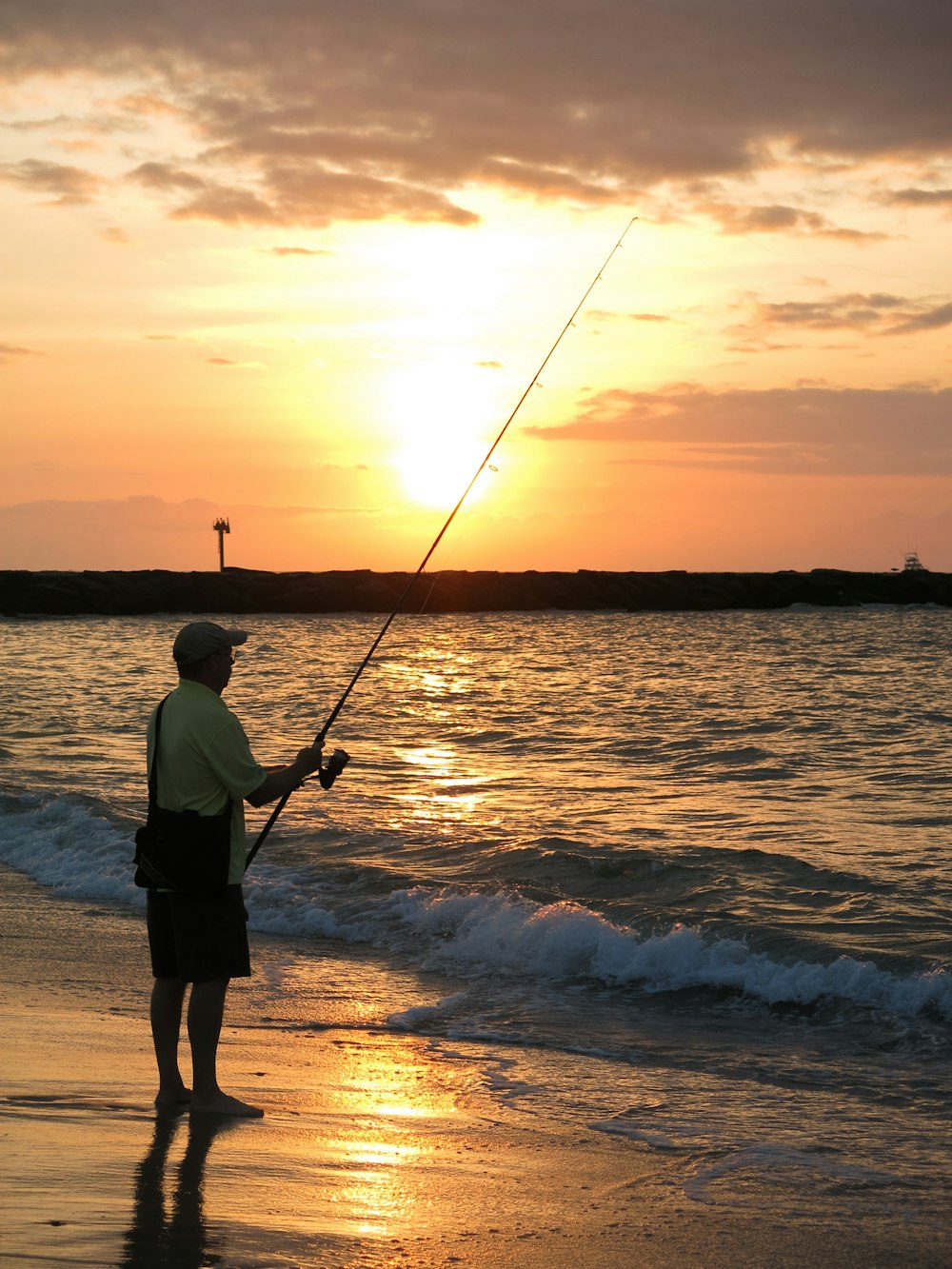 Mann fischt während der goldenen Stunde am Ufer